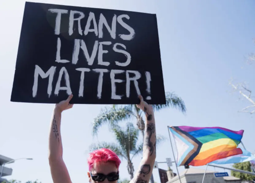 Progress Pride Flag during Drag March LA with a Trans Lives Matter sign, West Hollywood, California, April 9, 2023