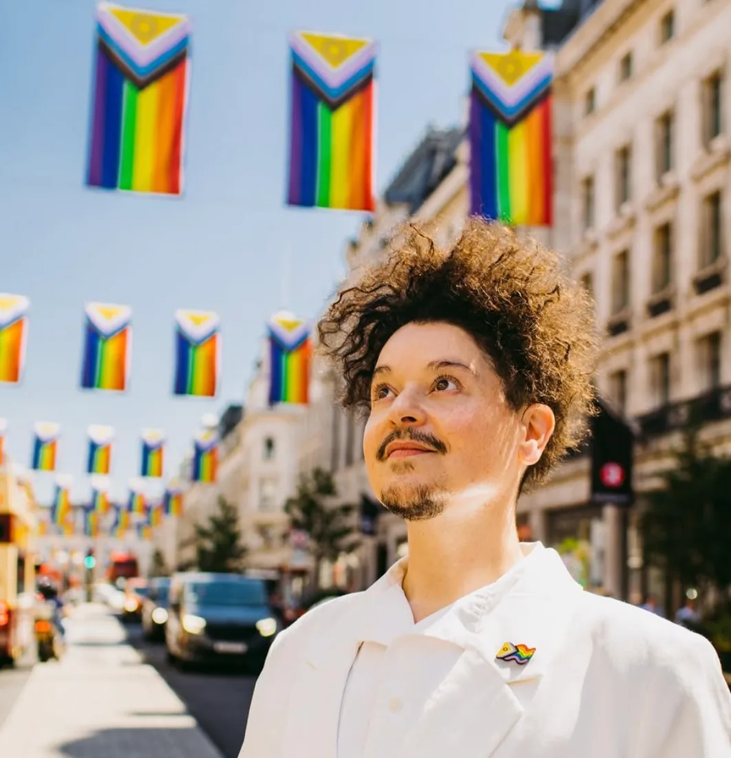 Person standing beneath Intersex-Inclusive Progress Pride flags on Regent Street, London, June 2022