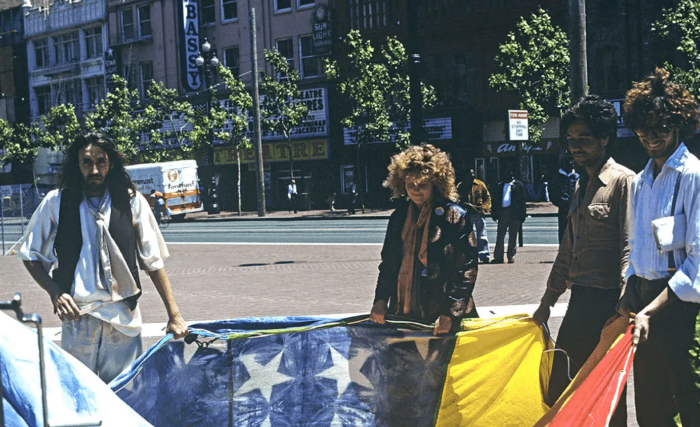 Gilbert Baker, Lynn Segerblom, Robert Guttman and a volunteer holding up one of the original rainbow flags in San Francisco in 1978.