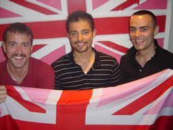 Three men holding a Pink Jack indoors at the EuroPride 2006 stall.