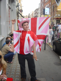 A man in a pink hat wearing a Pink Jack as a cape on a London street during EuroPride 2006.