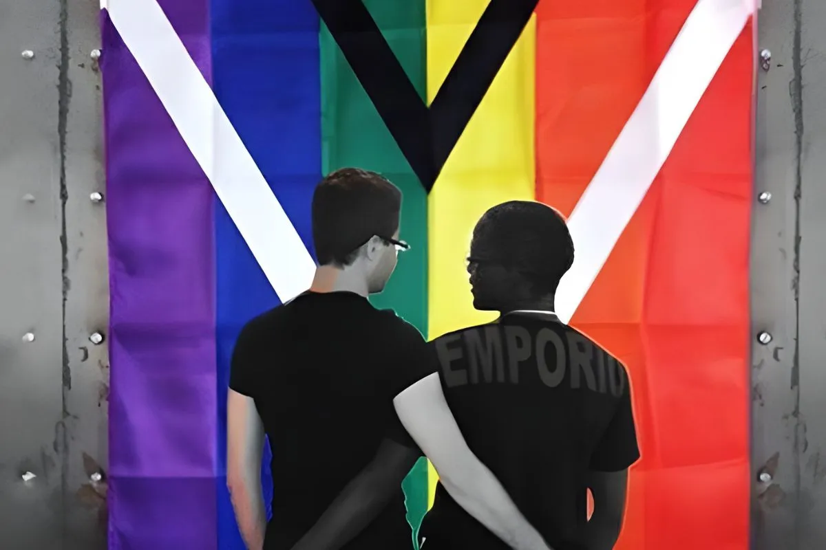 The flag hung vertically on a corrugated wall, so that the pall reads as an upright Y, with two men standing in front of it with their backs to the camera.